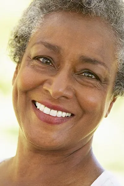 woman smiling after AZ Dental helped restore her smile using dental implants