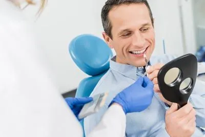 man color-matching his teeth with new dental veneers at AZ Dental