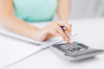 woman keeping track of her finances using a calculator