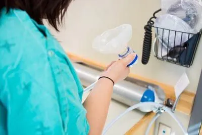 patient holding the device used to provide laughing gas for dental procedures